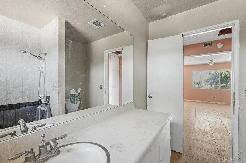 39635 Manzanita Dulce Road Boulevard, CA 91905 - Photo 11 of 33 a spacious bathroom with a granite countertop sink and a mirror