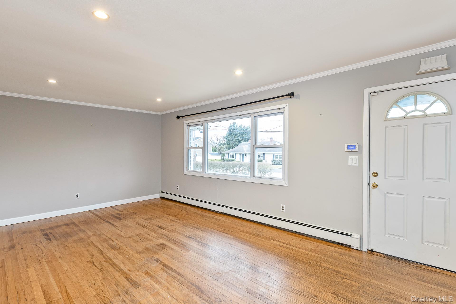 5 Richlee Street Blue Point, NY 11715 - Photo 5 of 27 an empty room with wooden floor and windows