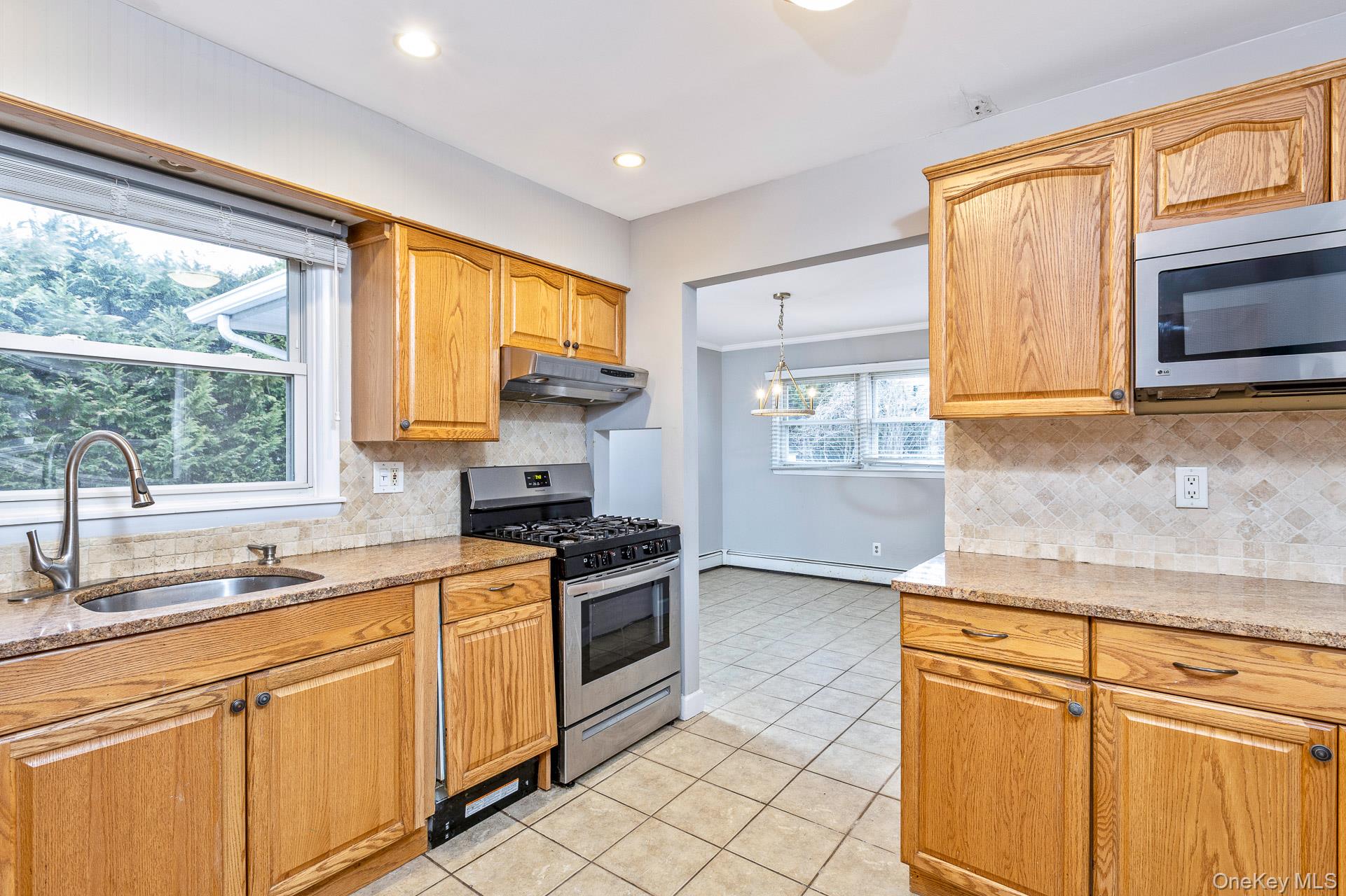 5 Richlee Street Blue Point, NY 11715 - Photo 9 of 27 a kitchen with stainless steel appliances white cabinets a sink and a stove