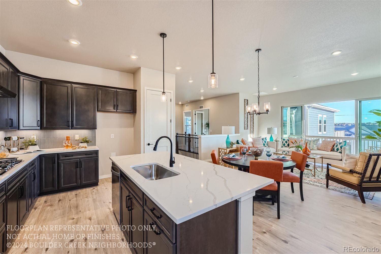 a kitchen with stainless steel appliances kitchen island granite countertop a sink a stove and a wooden floors