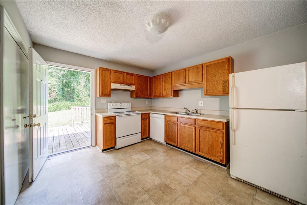 4355 East Paulding Drive, Unit A Dallas, GA 30157 - Photo 3 of 29 a kitchen with stainless steel appliances granite countertop a refrigerator a sink dishwasher a stove with white cabinets and wooden floor