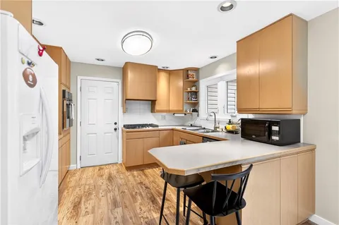 a kitchen with stainless steel appliances granite countertop a sink a stove and a refrigerator