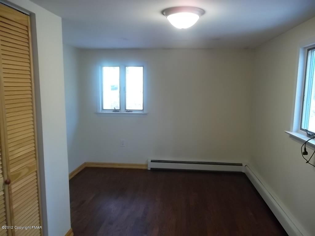 102 Rock Road Dingmans Ferry, PA 18328 - Photo 11 of 13 an empty room with wooden floor and windows