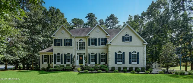 a front view of a house with a yard and trees