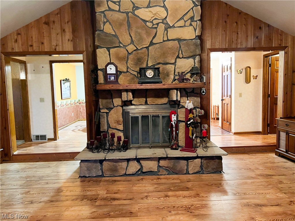 10263 Cemetery Road Burbank, OH 44214 - Photo 9 of 22 Living room with a stone fireplace, light wood-type flooring, and high vaulted ceiling