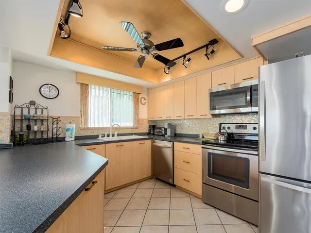 a kitchen with granite countertop a sink stainless steel appliances and cabinets