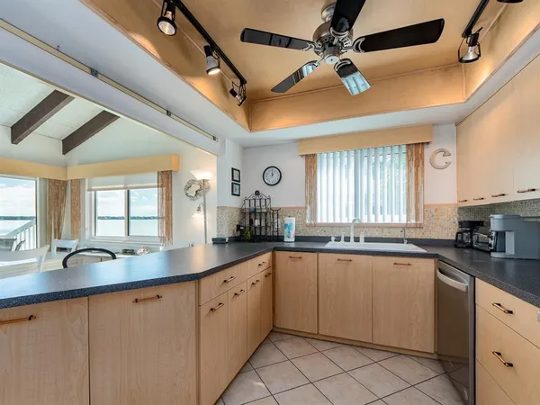 a kitchen with granite countertop cabinets a sink a window and stainless steel appliances