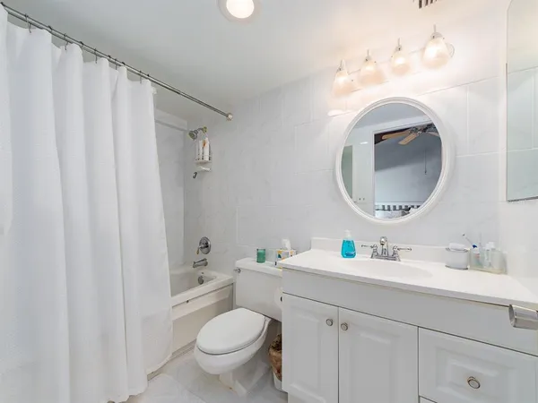 a bathroom with a toilet sink vanity and mirror