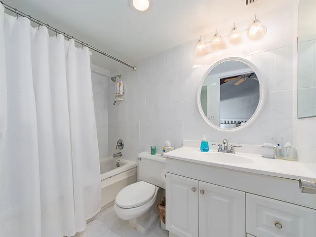 a bathroom with a toilet sink vanity and mirror