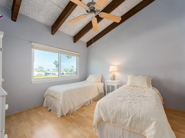 a bedroom with two beds and a large window