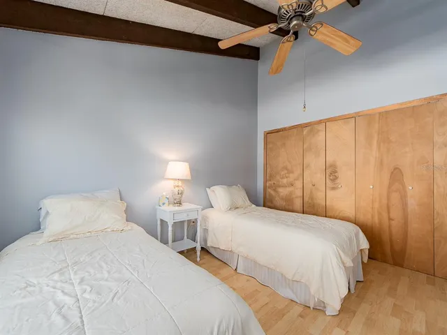 a bedroom with two beds and a ceiling fan