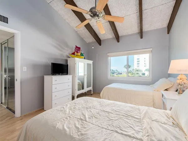 a bedroom with a bed and a flat tv screen on dresser