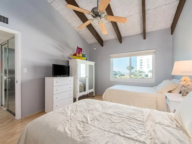 a bedroom with a bed and a flat tv screen on dresser