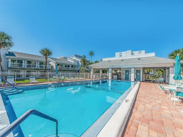a view of a house with pool and chairs