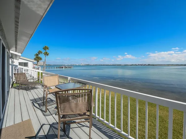 a view of a balcony with wooden floor and outdoor seating