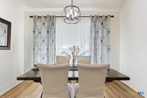 a view of a dining room with furniture and chandelier