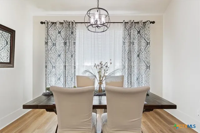a view of a dining room with furniture and chandelier