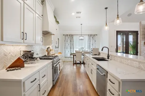 a kitchen with sink stove and cabinets
