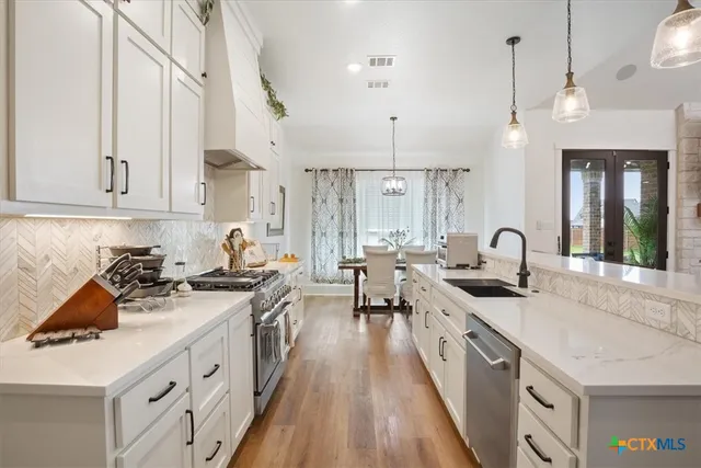 a kitchen with sink stove and cabinets