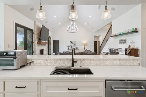 a kitchen with kitchen island granite countertop a sink a counter and cabinets