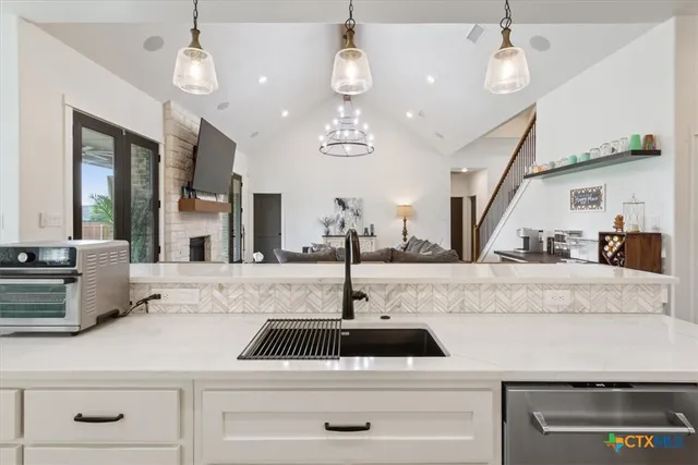 a kitchen with kitchen island granite countertop a sink a counter and cabinets
