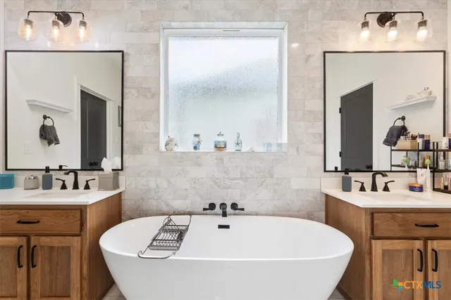 a bathroom with a tub sink and mirror