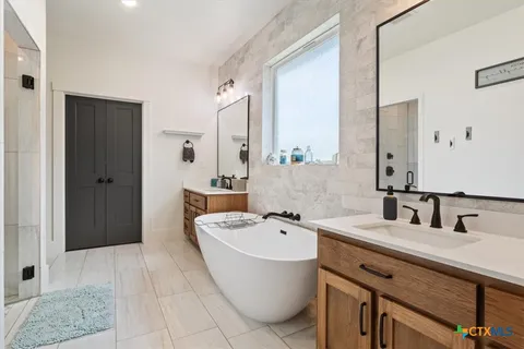 a bathroom with a double vanity sink a mirror and a shower