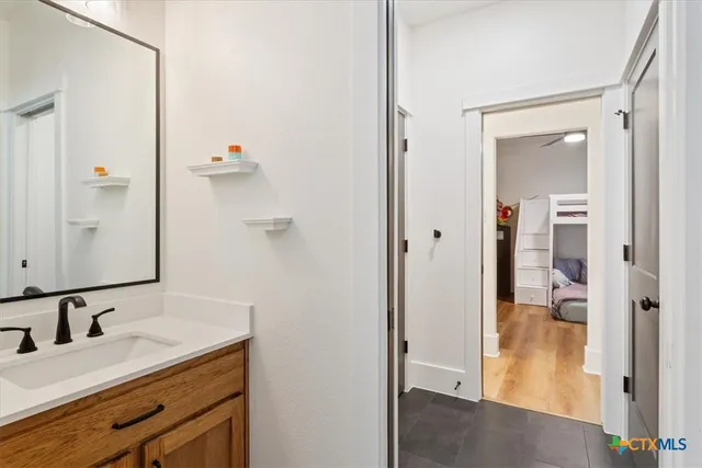 a bathroom with a granite countertop sink and a mirror