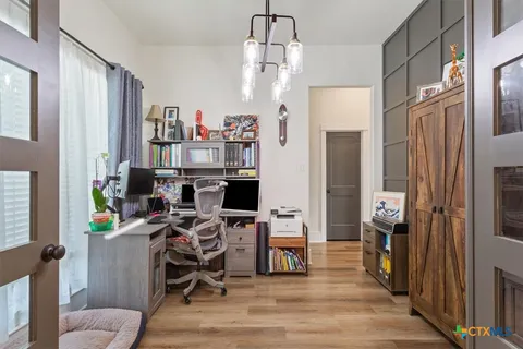 a view of a workspace with furniture and a window