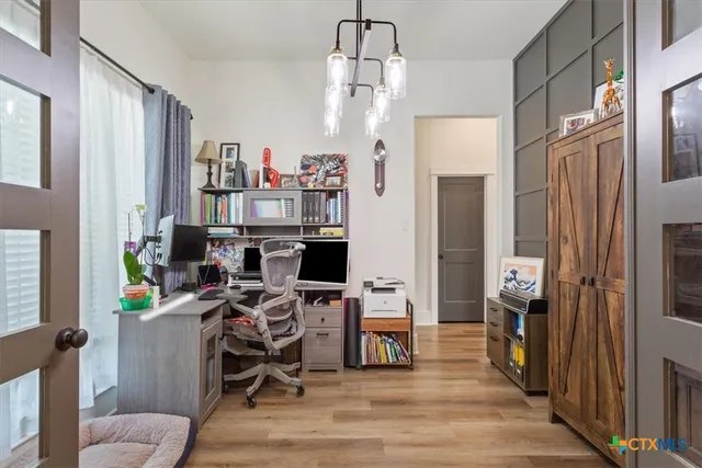 a view of a workspace with furniture and a window