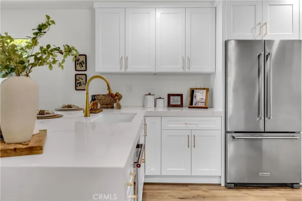 a kitchen with stainless steel appliances kitchen island a table chairs and a refrigerator