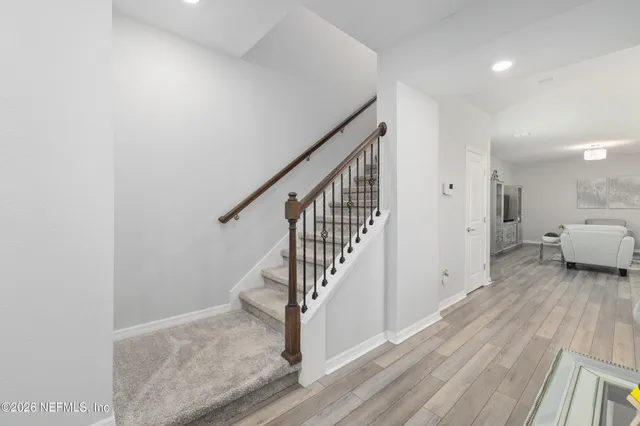 a large kitchen with stainless steel appliances kitchen island granite countertop a lot of counter space and wooden floors