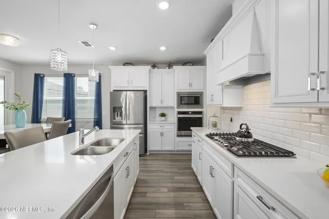 a kitchen with stainless steel appliances kitchen island granite countertop a kitchen island hardwood floor and a sink
