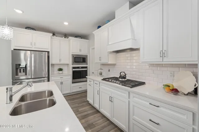a kitchen with white cabinets and stainless steel appliances