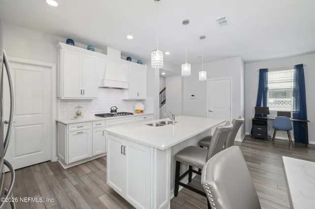 a living room with furniture a flat screen tv and a refrigerator