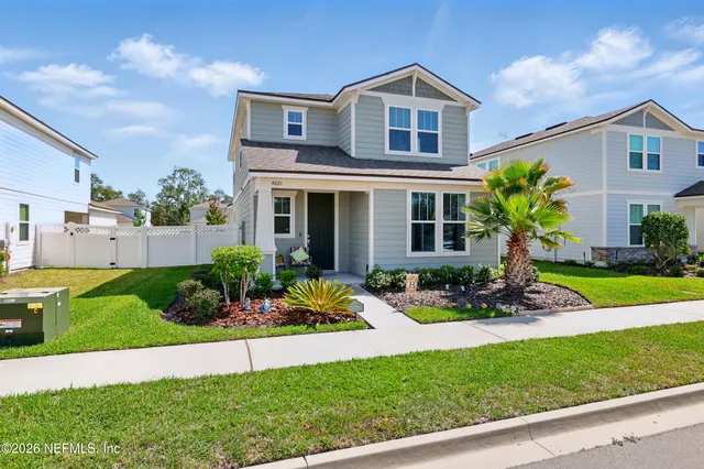 a front view of a house with a yard and potted plants