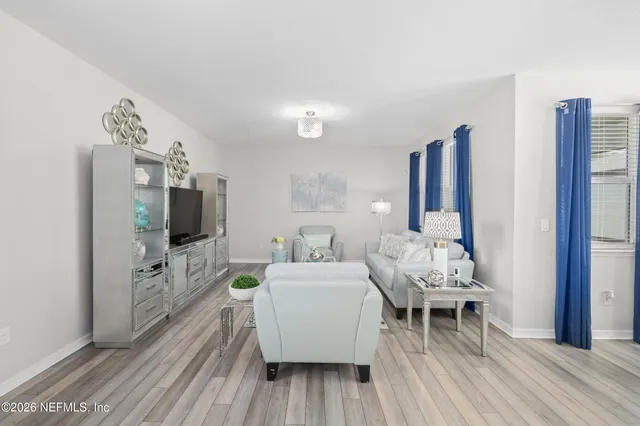 a living room with furniture and wooden floor