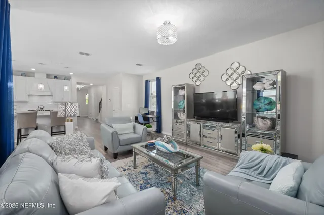 a bedroom with a bed a painting on the wall and a potted plant