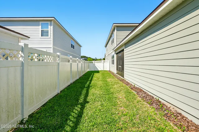 an aerial view of residential houses with outdoor space and parking