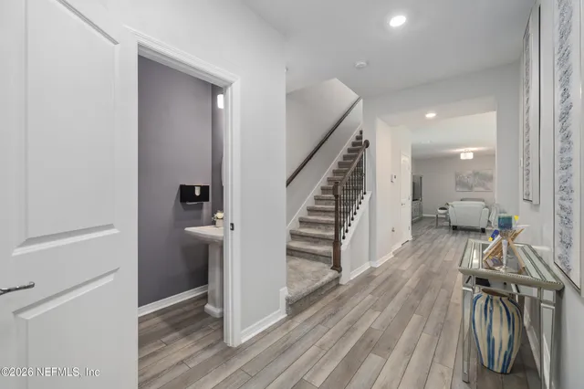 a view of a hallway with wooden floor and staircase
