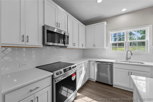 a kitchen with stainless steel appliances granite countertop a sink and a stove