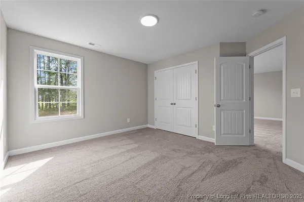 an empty room with windows and closet