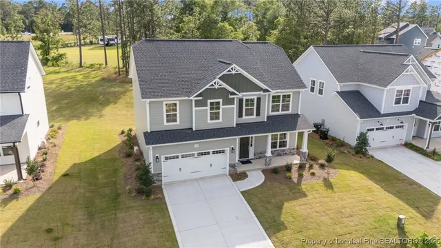 an aerial view of a house with swimming pool and large trees