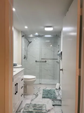 a bathroom with a granite countertop sink a mirror and a shower