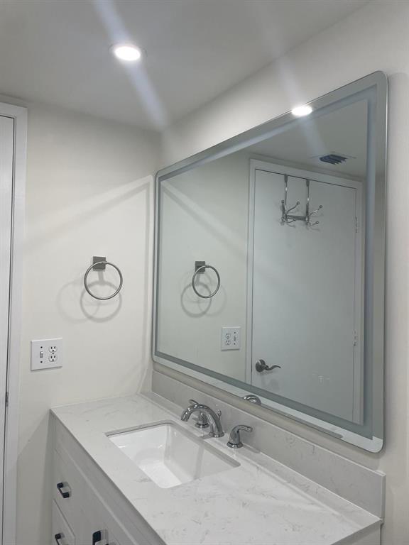 701 Southwest 142nd Avenue, Unit 411S Pembroke Pines, FL 33027 - Photo 7 of 9 a bathroom with a granite countertop sink a mirror and a shower