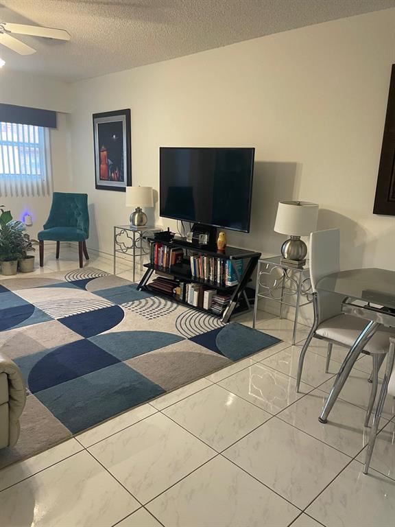 701 Southwest 142nd Avenue, Unit 411S Pembroke Pines, FL 33027 - Photo 9 of 9 a living room with furniture and a flat screen tv