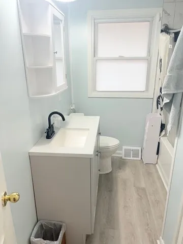 a bathroom with a sink toilet and window
