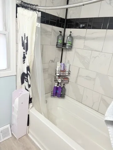 a bathroom with a bathtub and a shower