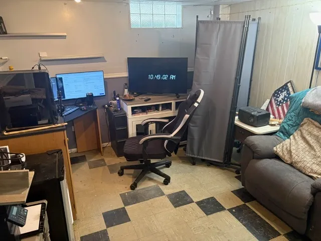 a view of a workspace with furniture and a window