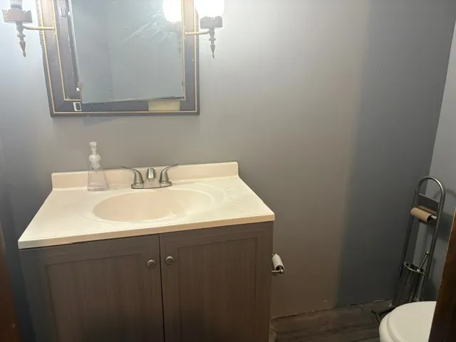 a bathroom with a sink toilet and mirror